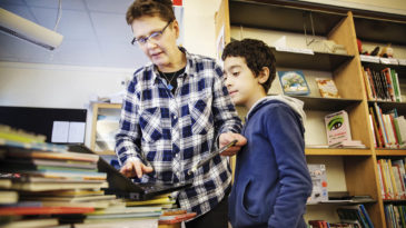 Skolbiblioteket är alltid öppet på lunchrasterna. Oftast brukar ett tjugotal ungdomar komma in på lunchen för att låna med sig böcker, sitta och plugga eller pilla med mobilen i lugn och ro. Foto: Linus Sundahl-Djerf.